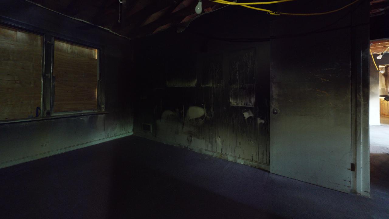 A dark room with a door and a window.