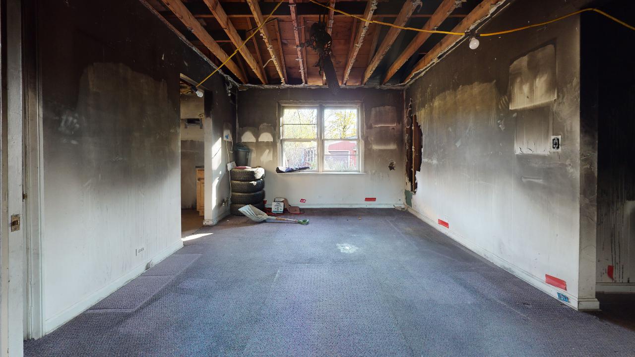 An empty room with a carpeted floor and a window.
