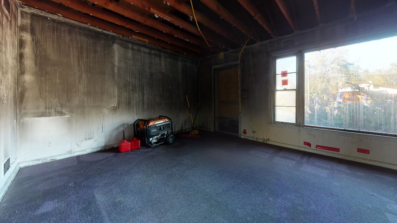 An empty room with a carpeted floor and a window.