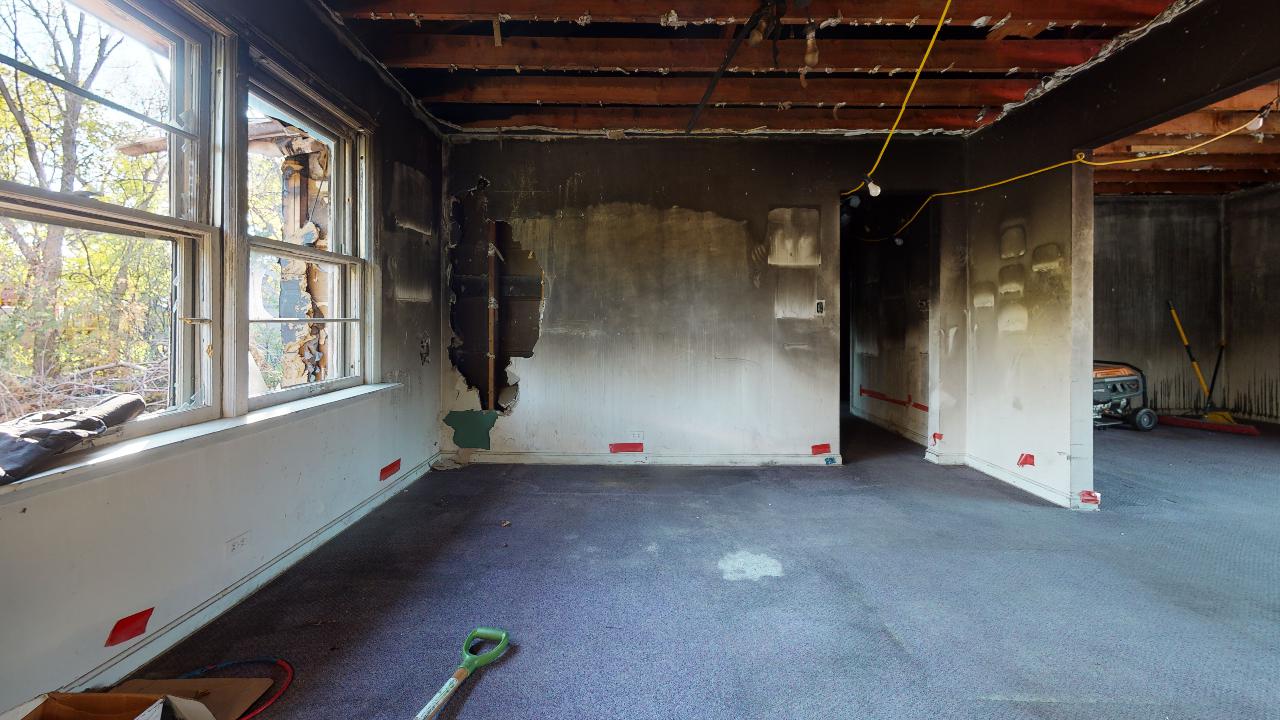 A room with a lot of windows and a vacuum cleaner in it.