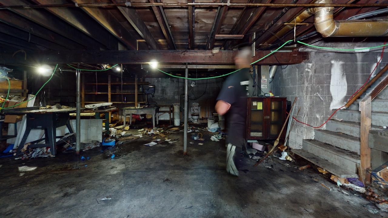 A man is standing in the basement of a house.