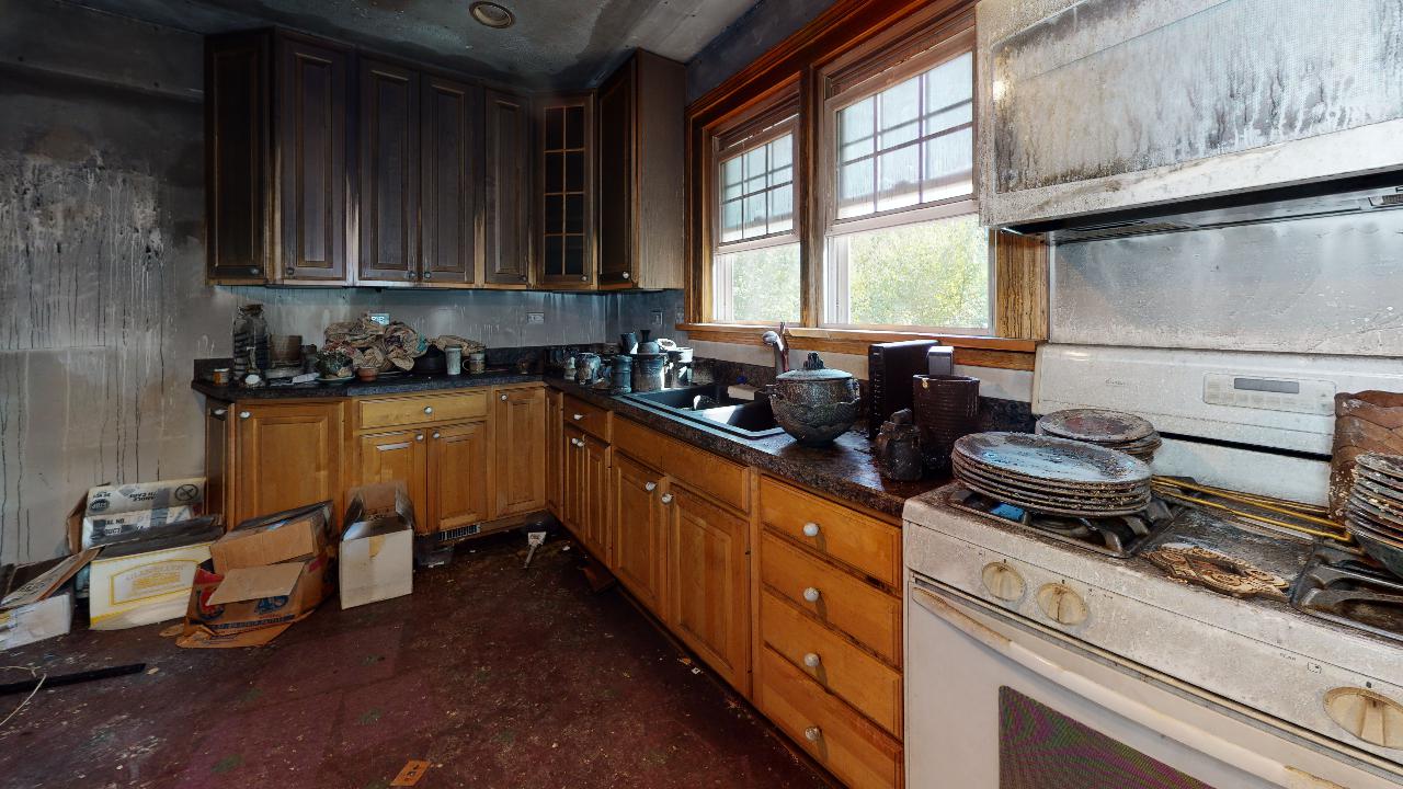 A kitchen with wooden cabinets , a stove , and a sink.