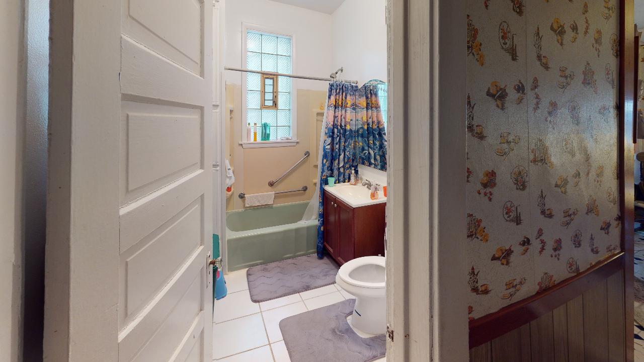 A bathroom with a toilet , sink , tub and shower.