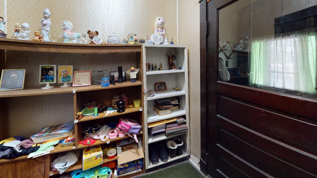 A room with a lot of shelves and a door.