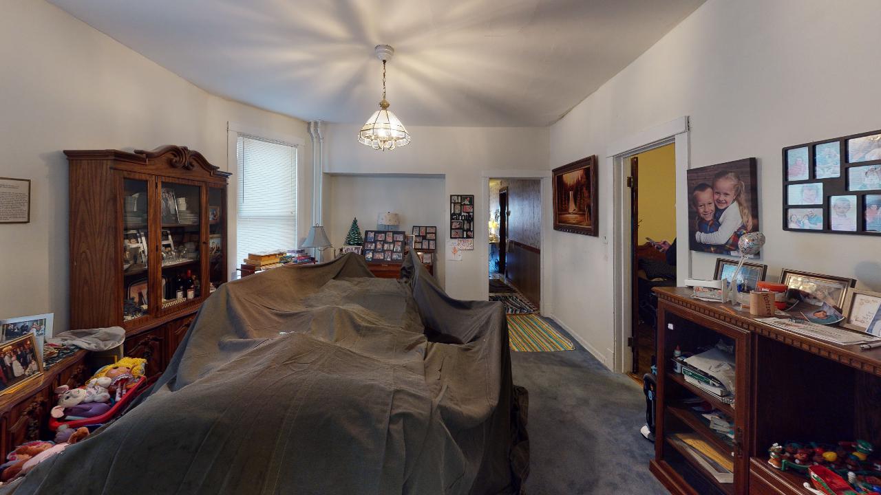 A living room with a couch covered in a blanket.