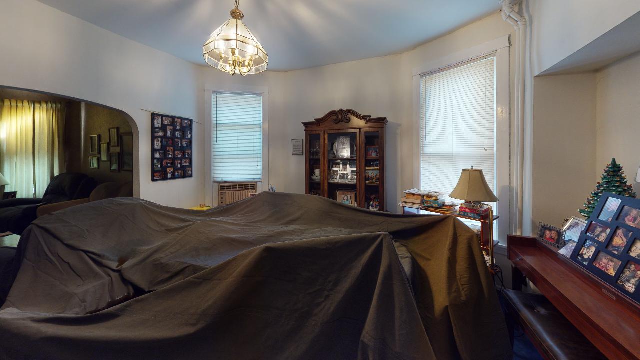A living room with a table covered in a black cloth.