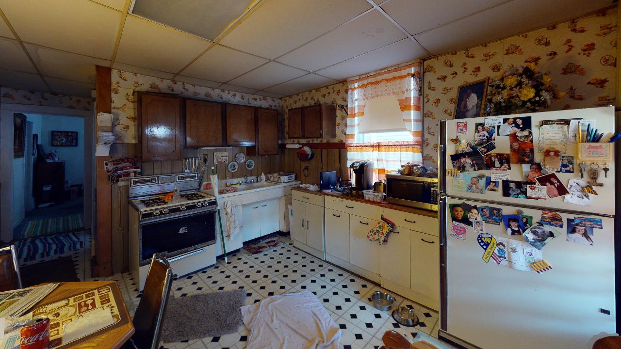 A kitchen with a refrigerator , stove , sink , and microwave.