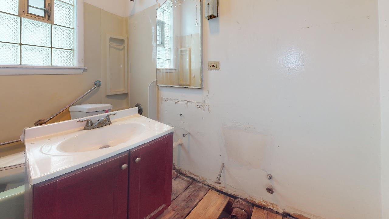 A bathroom with a sink , toilet and mirror.