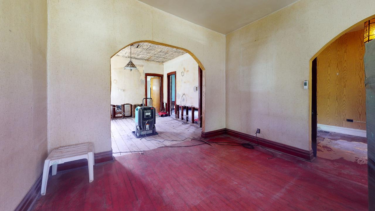 An empty room with a red floor and a white table.