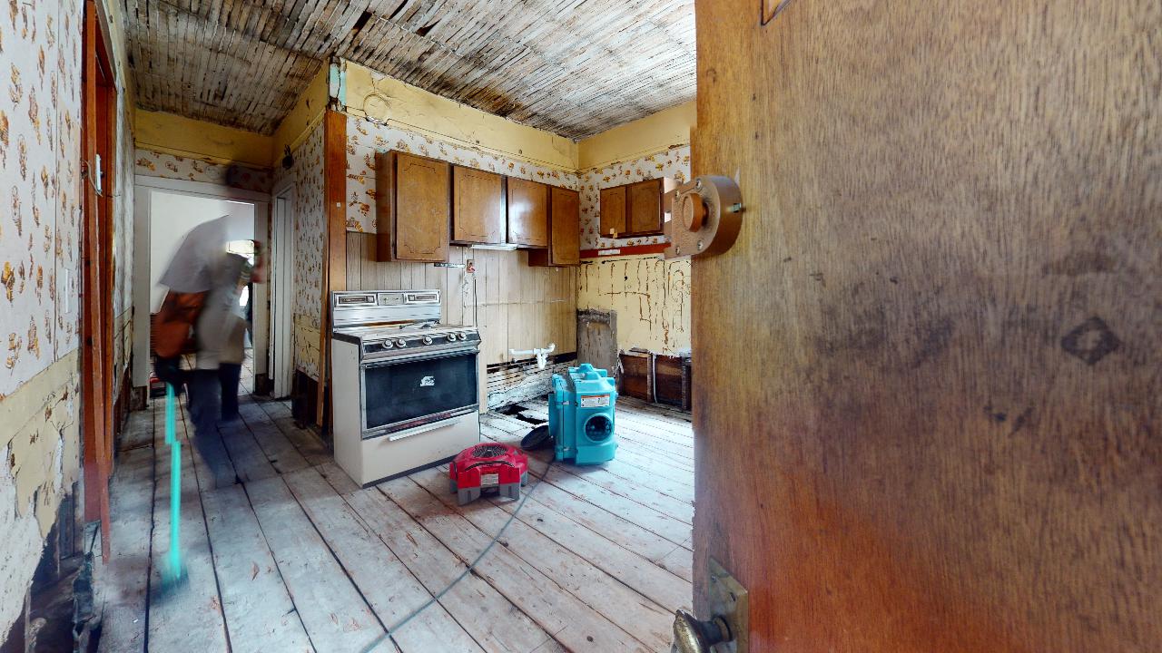 A kitchen with a stove and a vacuum cleaner in it.