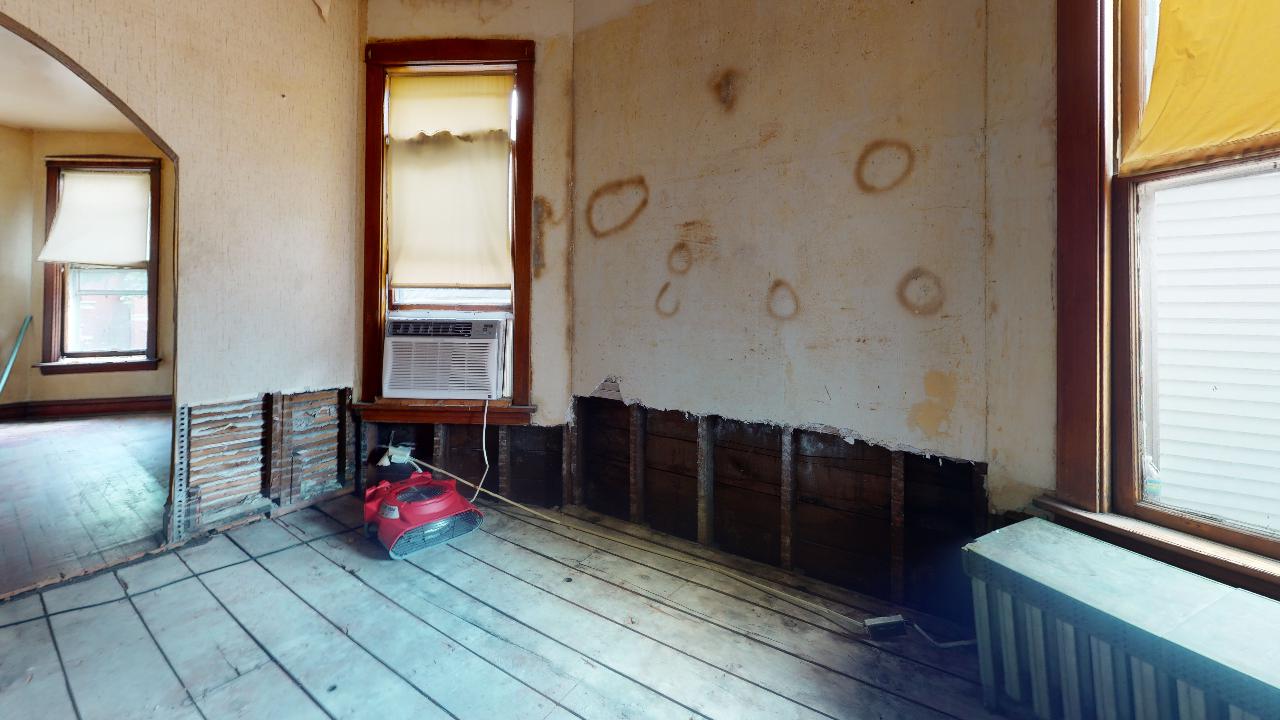 An empty room with a wooden floor and a window.