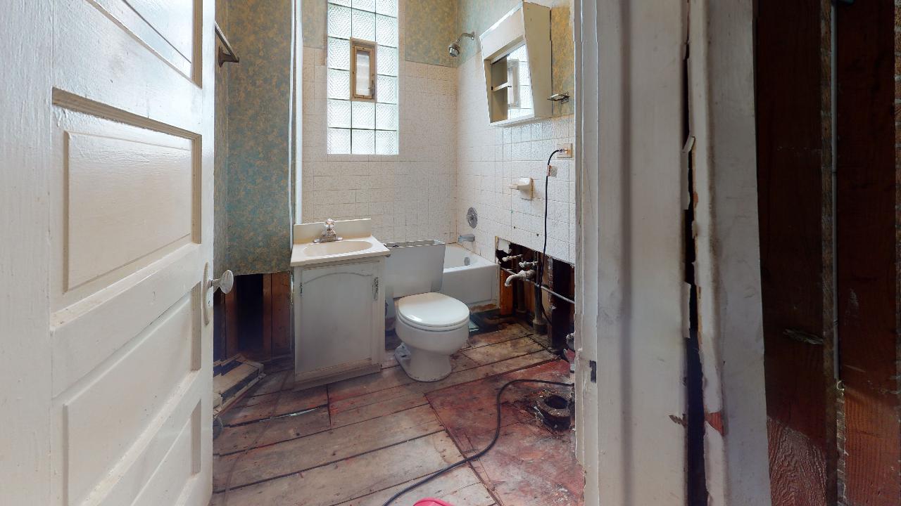A bathroom with a toilet , sink , and bathtub.