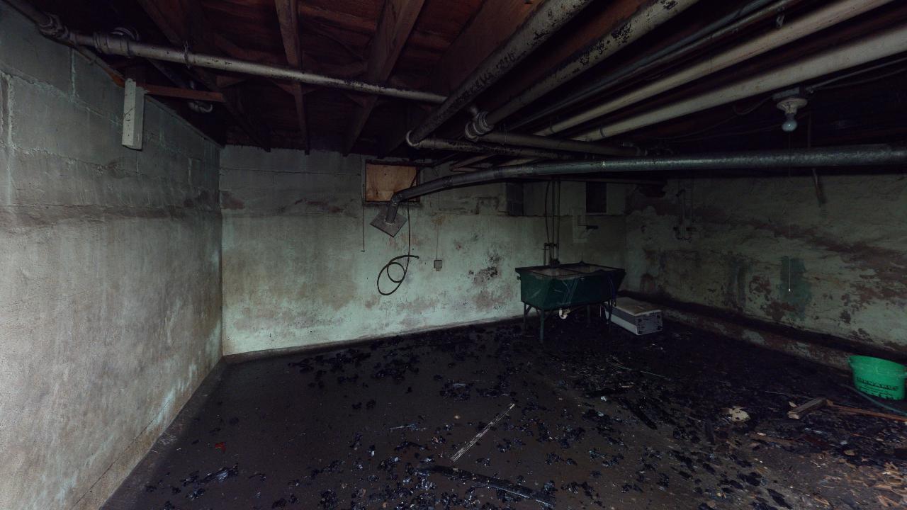 An empty basement with a lot of pipes coming out of the ceiling.