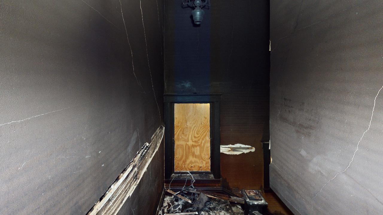 A dark hallway with a door in the middle of it.