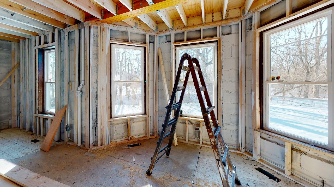 An empty room with a ladder in the middle of it.