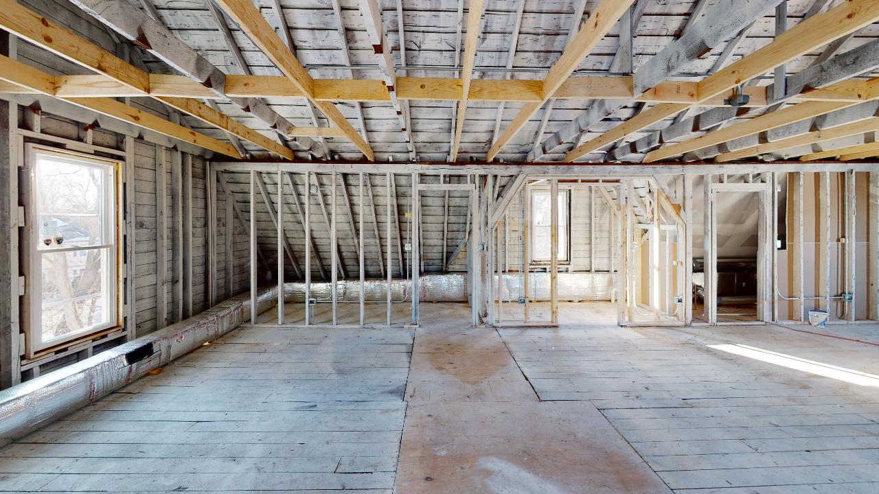 An empty room in a house under construction with wooden beams.