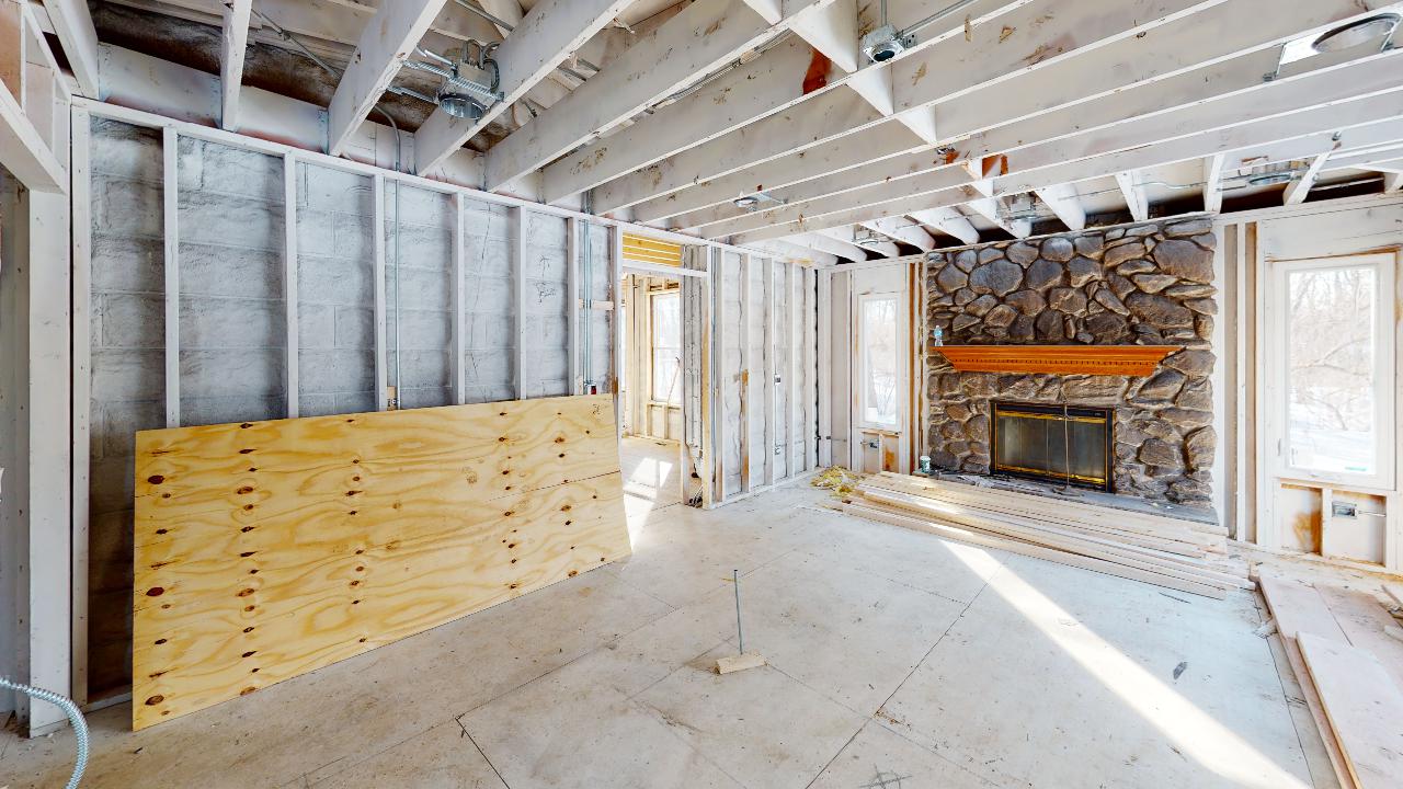 A living room in a house under construction with a fireplace.