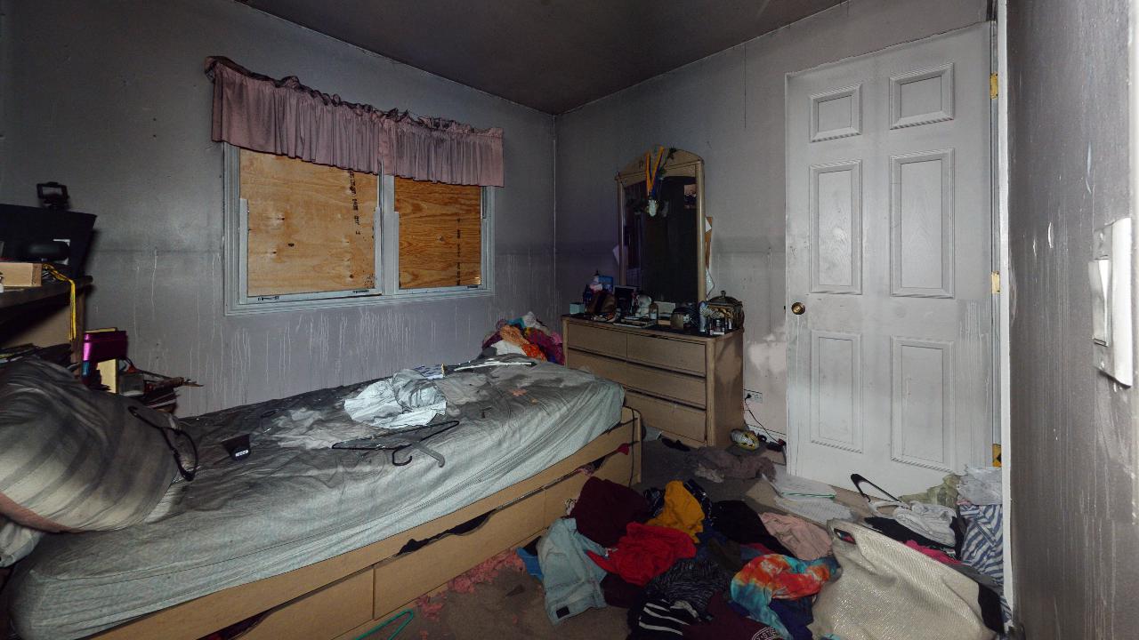 A bedroom with a bed , dresser , mirror and window.