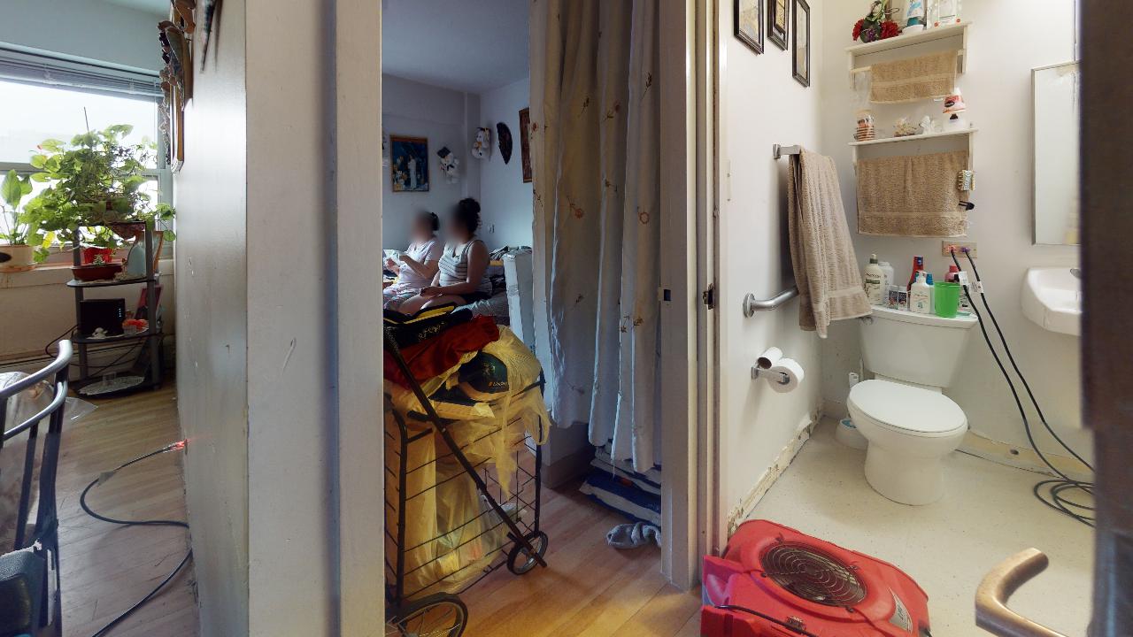 A bathroom with a toilet , sink , and shower curtain.
