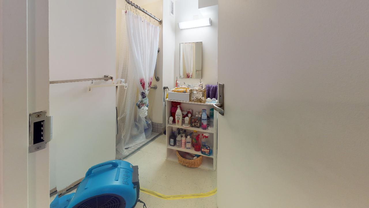 A bathroom with a blue vacuum cleaner in the middle of it.