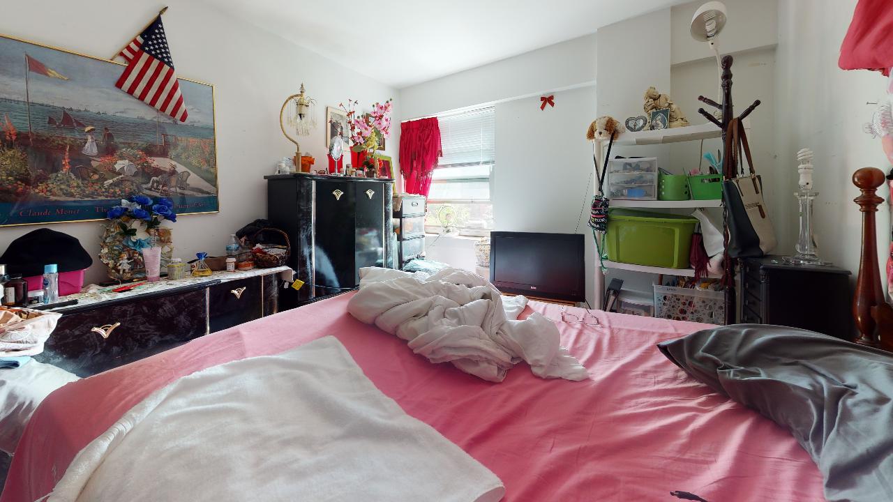A bedroom with a bed and a painting on the wall.