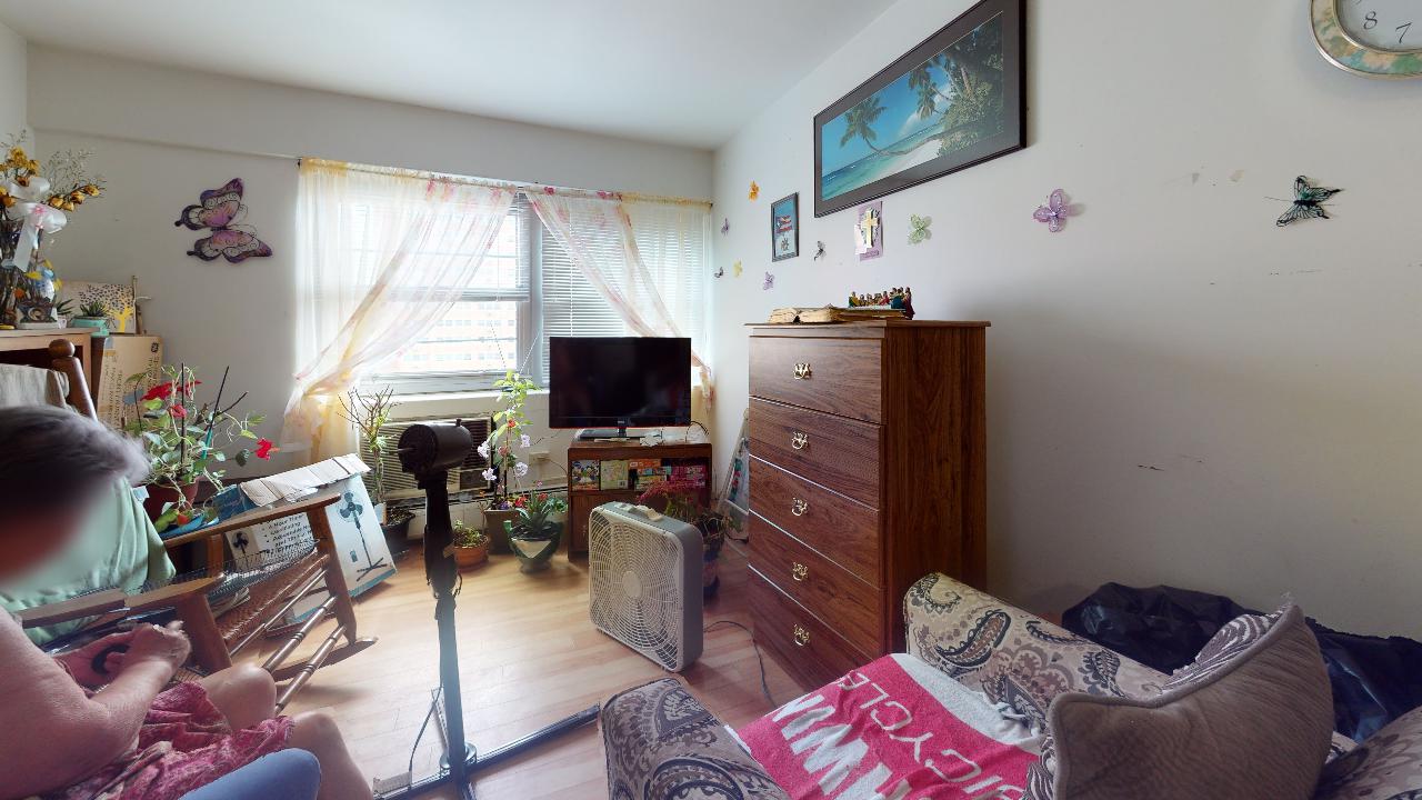 A person is sitting on a couch in a living room.