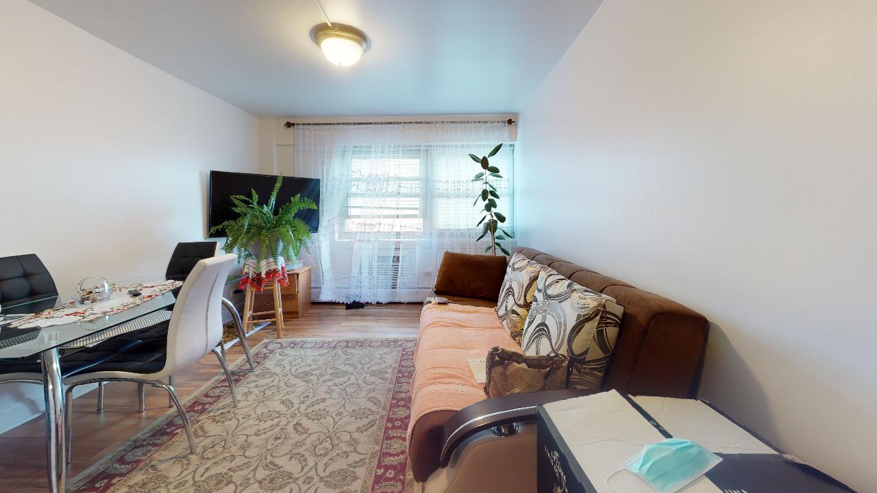 A living room with a couch , table , chairs and a tv.