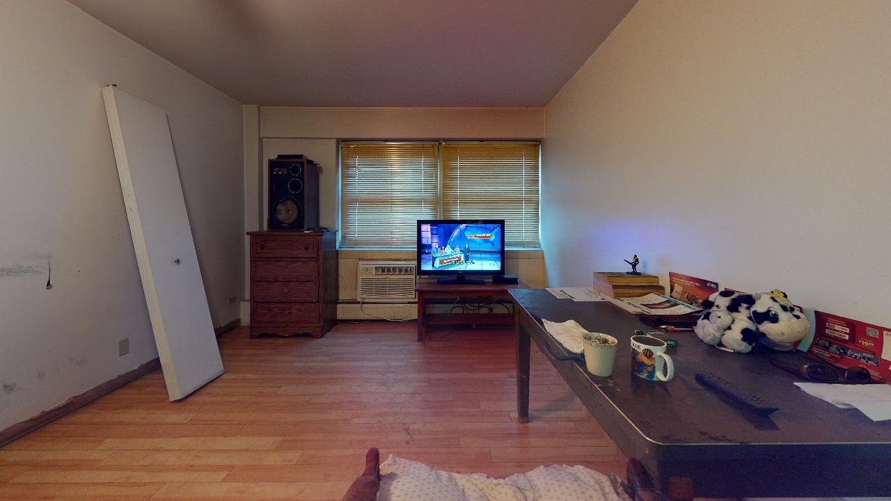 A living room with a table and a flat screen tv