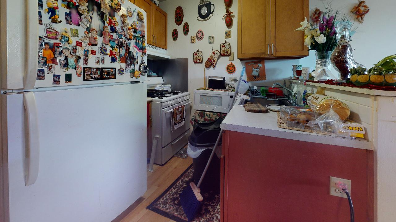 A kitchen with a refrigerator , stove , sink , and microwave.