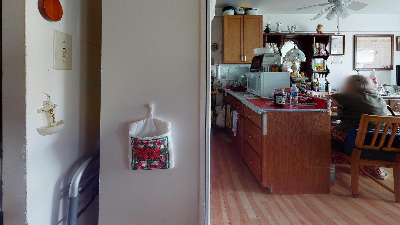 A person is sitting at a table in a kitchen.