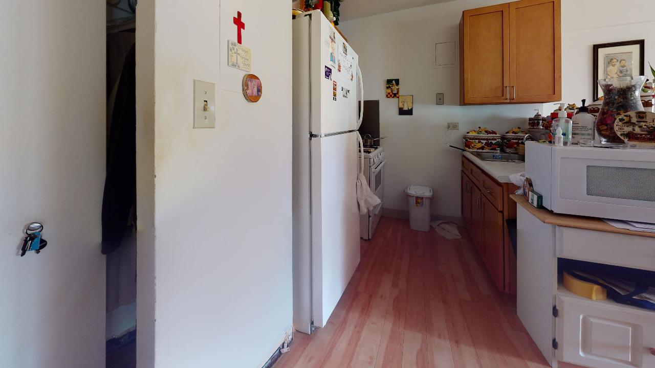 A kitchen with a refrigerator , microwave , sink , and cabinets.
