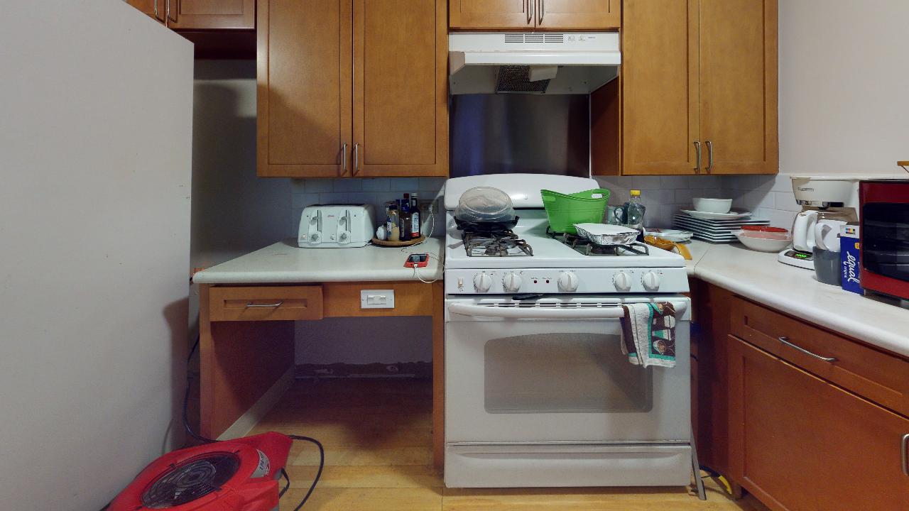 A kitchen with wooden cabinets and a white stove