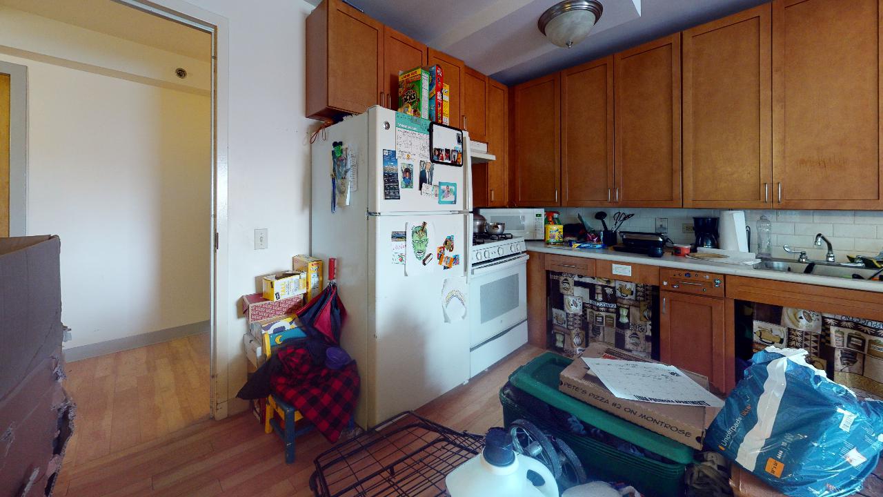 A kitchen with a refrigerator , stove , and microwave.