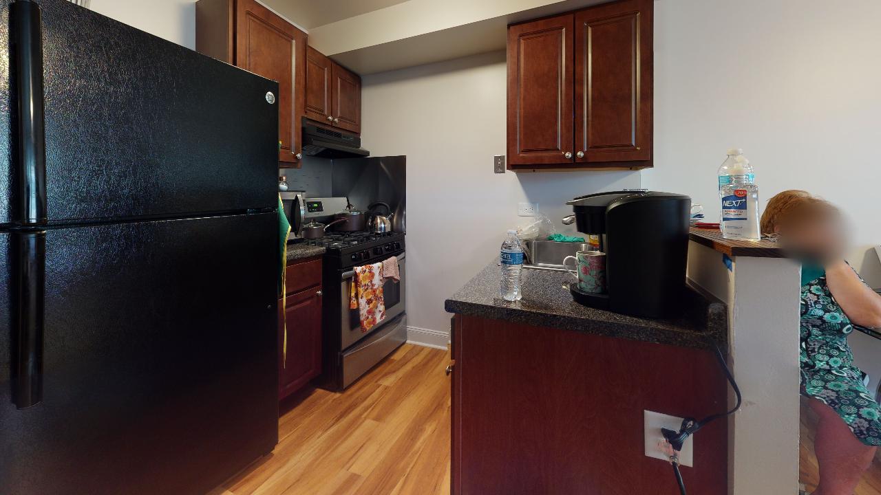 A kitchen with a black refrigerator , stove , and sink.