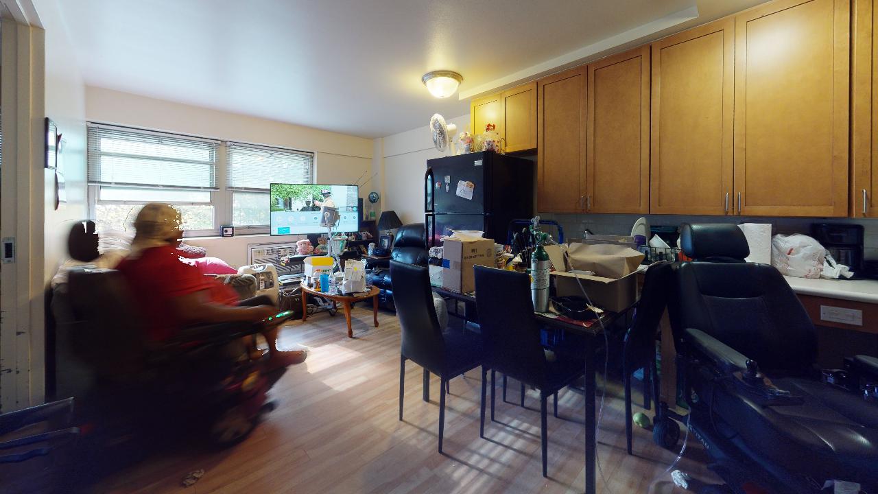 A woman in a wheelchair is sitting in a living room.