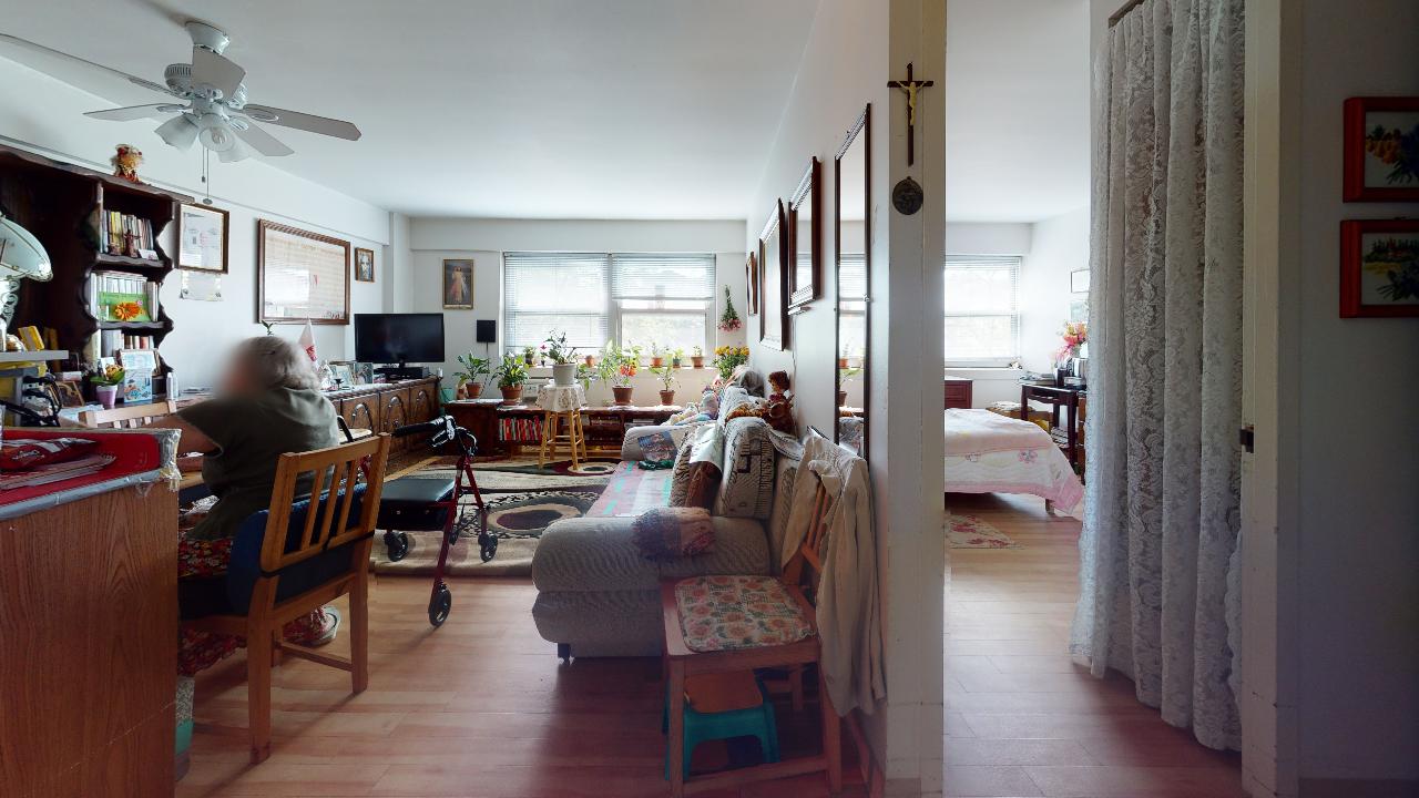A living room with a couch , chairs , and a ceiling fan.