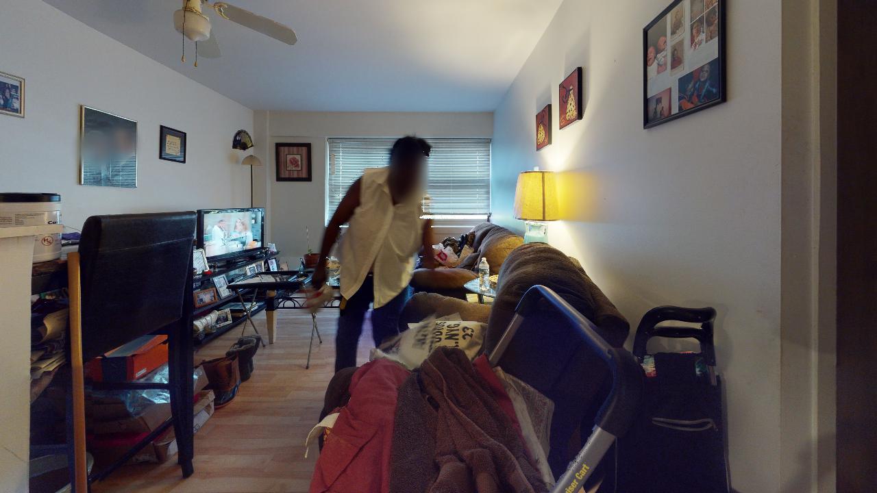 A woman is standing in a living room with a stroller.