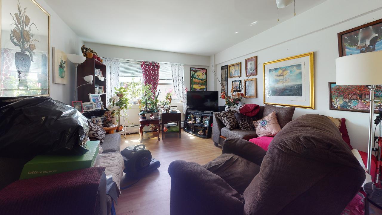 A living room with a lot of furniture and paintings on the wall.