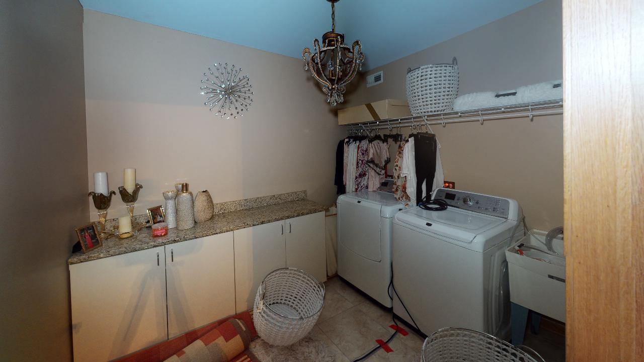 A laundry room with a washer and dryer and a sink.