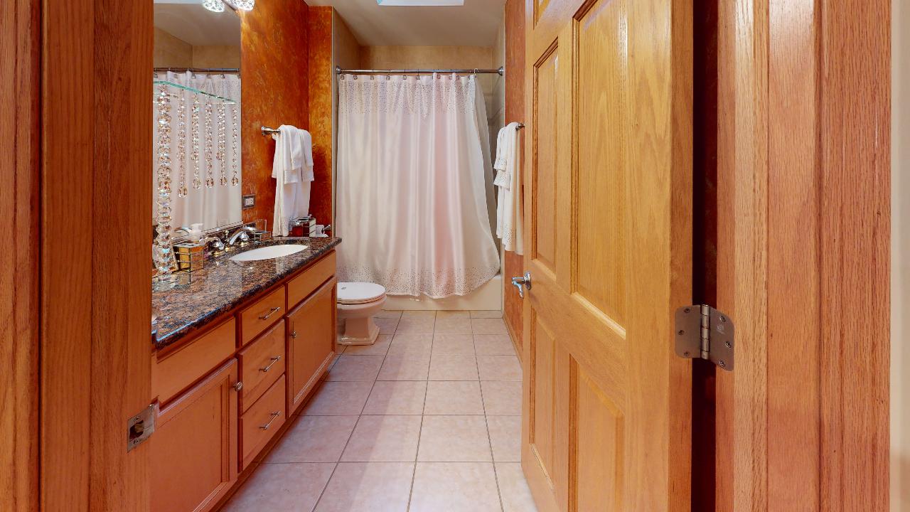 A bathroom with two sinks , a toilet , and a shower curtain.