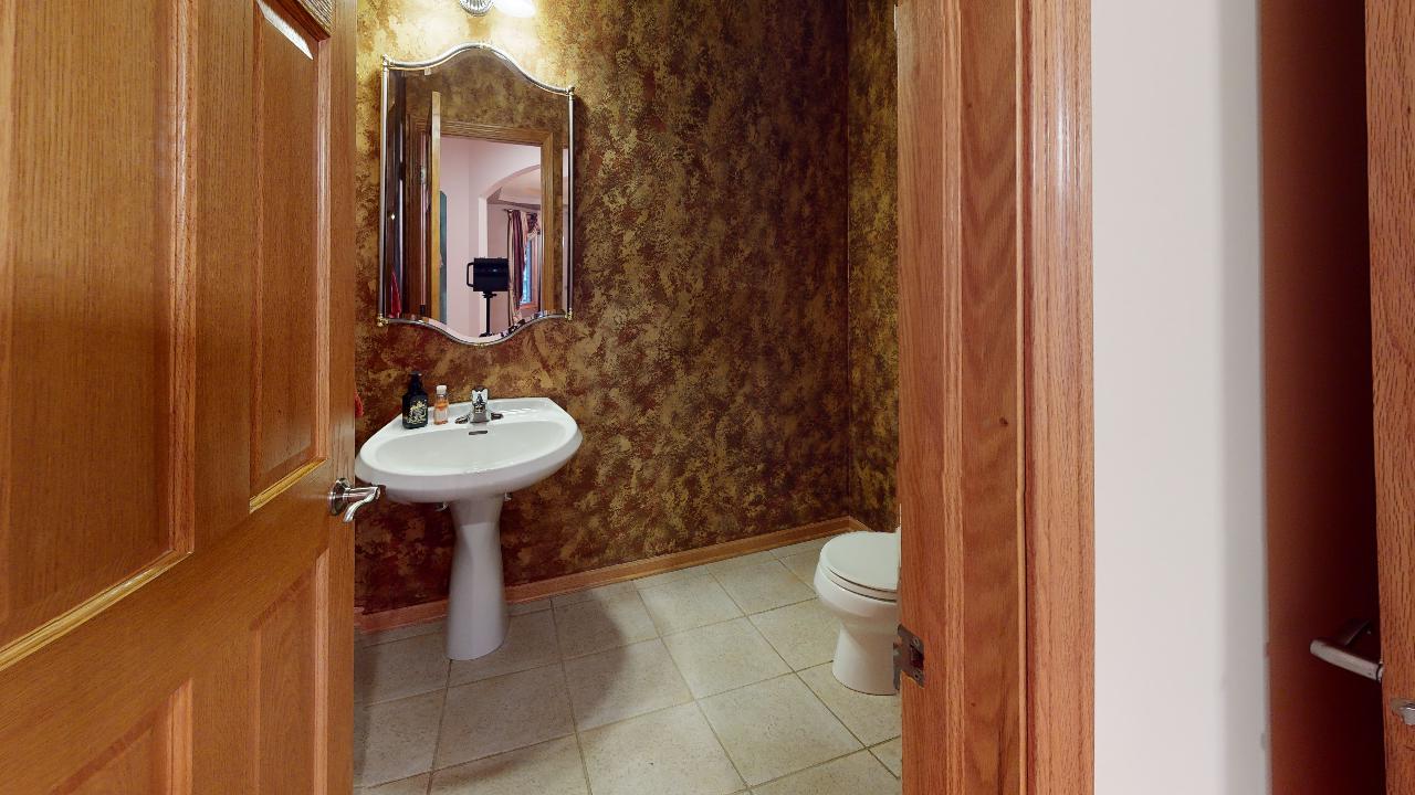 A bathroom with a sink , toilet and mirror.