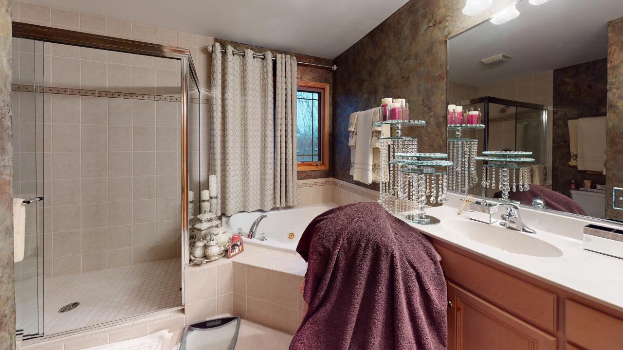 A bathroom with a tub , sink , and mirror.