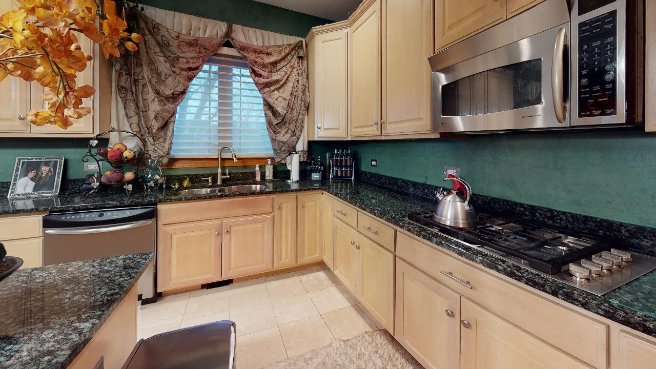 A kitchen with stainless steel appliances and granite counter tops.
