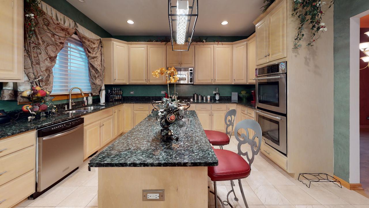 A kitchen with granite counter tops and stainless steel appliances