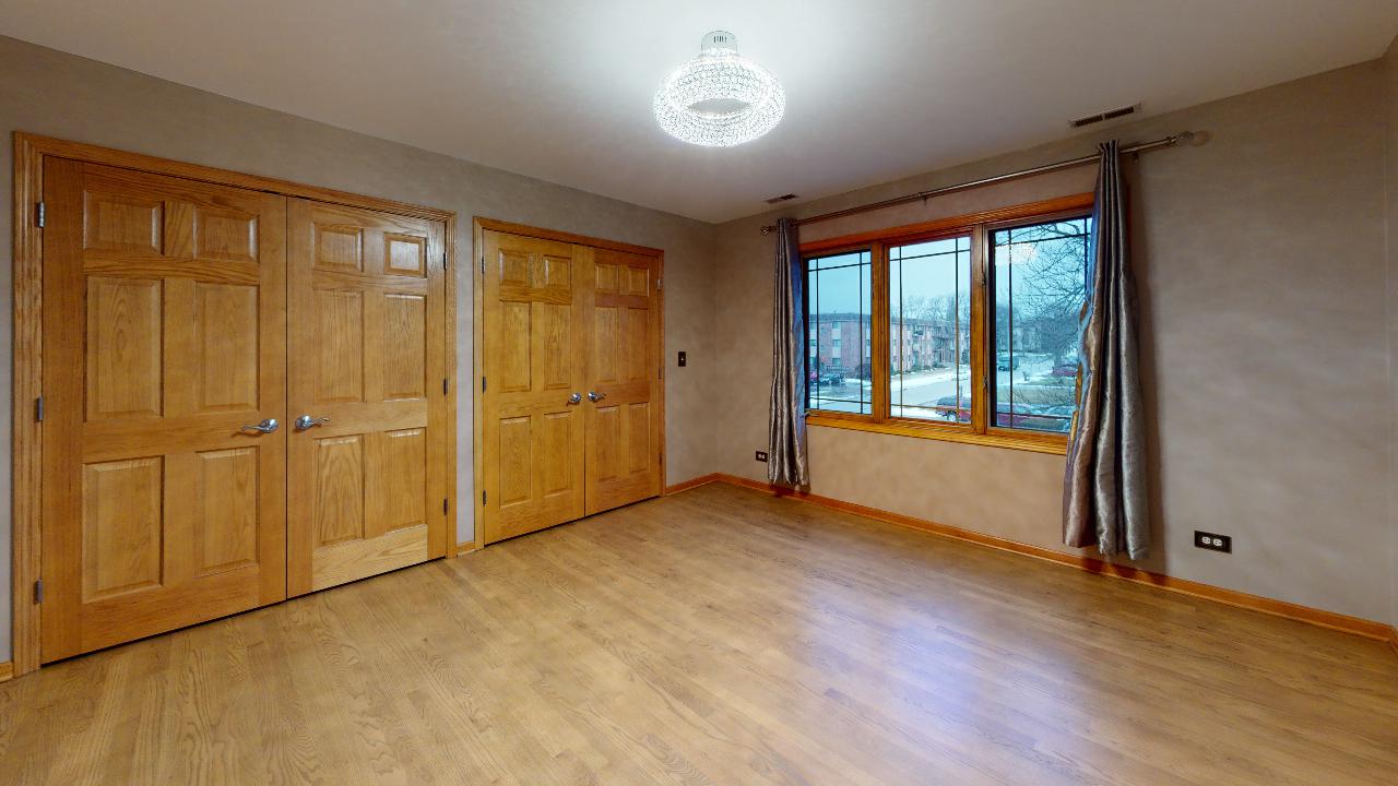 A large empty room with hardwood floors and lots of windows.
