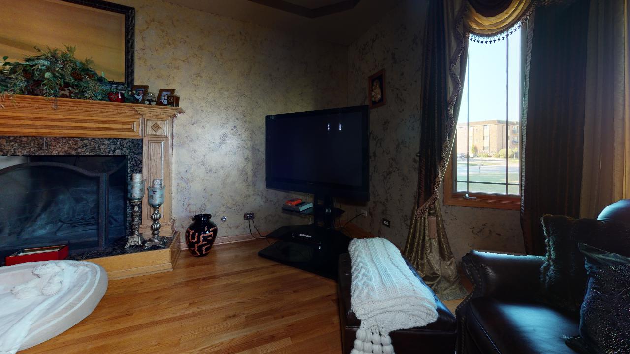A living room with a fireplace and a television.