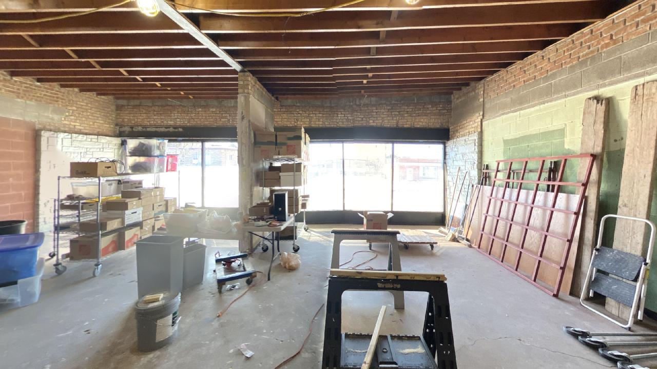 A large empty room with a brick wall and a wooden ceiling.