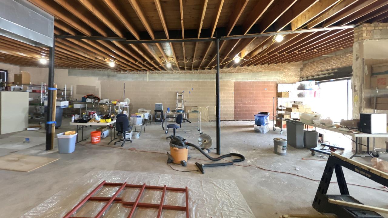 A large room with wooden beams and a vacuum cleaner in it.