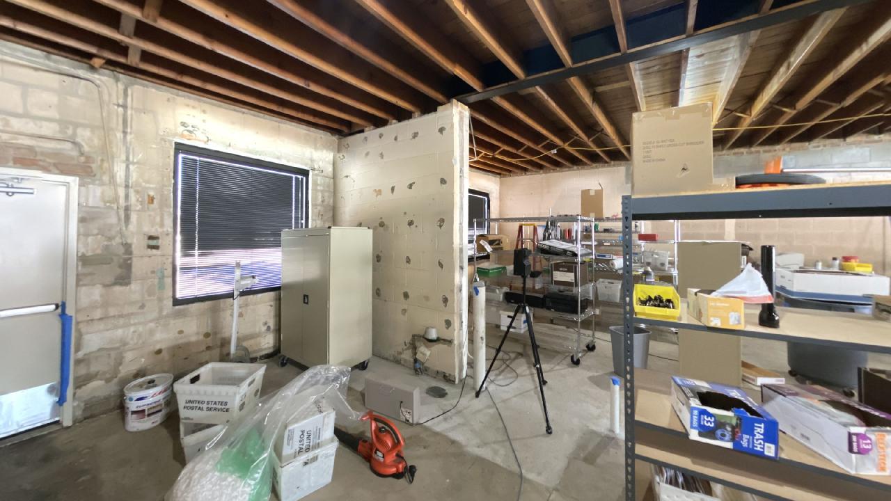 A room with a lot of shelves and boxes on the floor.