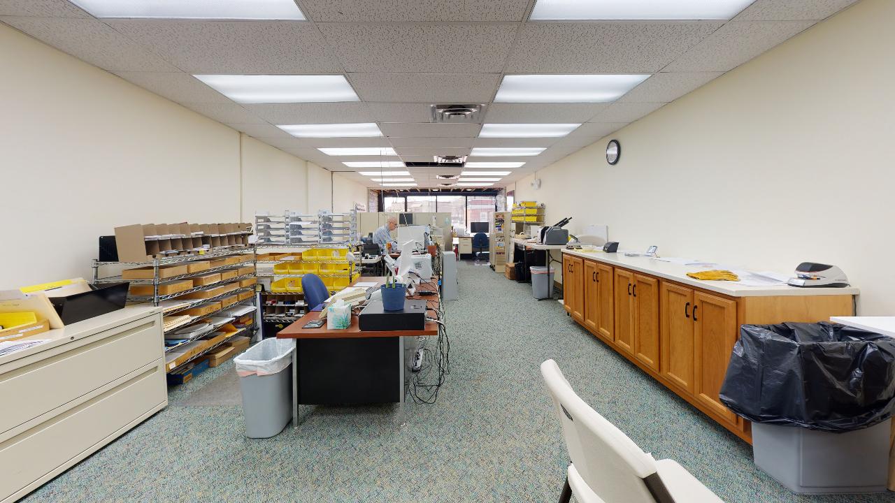 A large empty office with a lot of desks and cabinets.